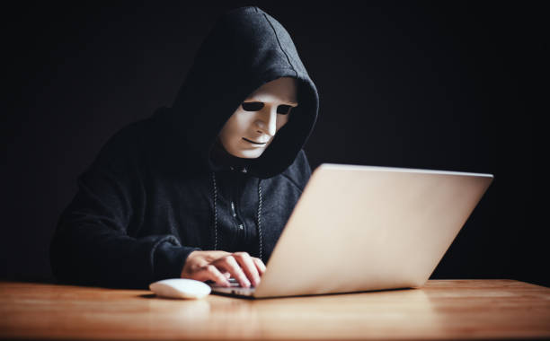 istock Black hat hacker in hood using tablet on desk to hacking privacy sensitive data cyber crime hack in dark room background matrix binary code. Cyber security cyber crime concept. Hacking phishing 1497395433