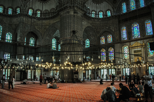 Inside Blue mosque, people and big chandelier