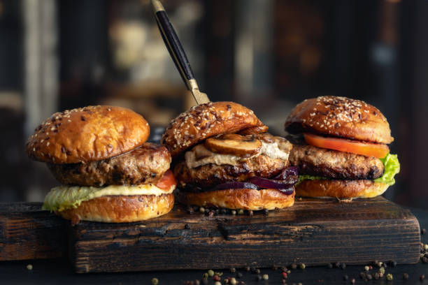 istock three different brutal burgers on wooden board in burger joint 1497395678
