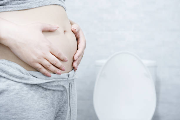 istock Chronic Constipation with a woman who can't pass stools regularly hand holding big abdominal 1497400066