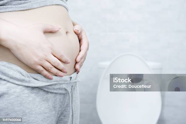 Chronic Constipation With A Woman Who Cant Pass Stools Regularly Hand Holding Big Abdominal Stock Photo - Download Image Now