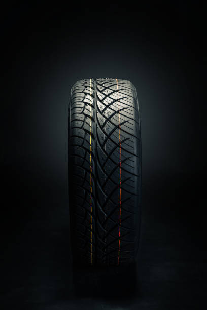 istock Brand new modern car tyre on a black background. Studio shot 1497402887