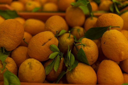 Closeup of tangerine heap, peeled and whole, in the outdoor market stall. Sao Paulo city, Brazil