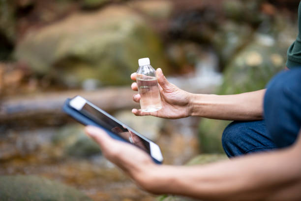 Young man using technology in forest for scientific research supporting a sustainable supply chain.