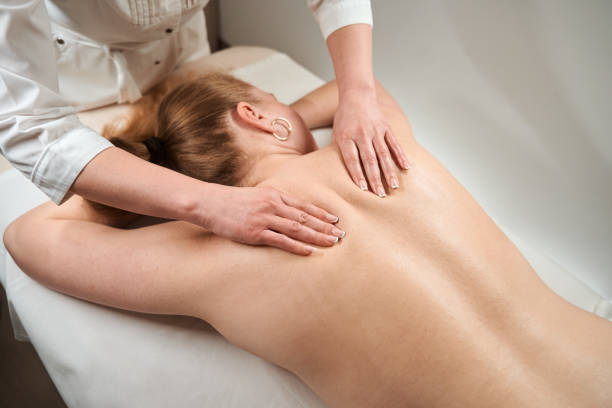 istock Masseuse in clinic makes a manual massage to a client 1497415087