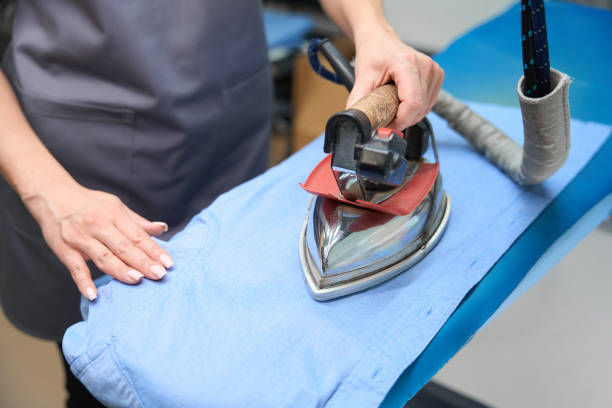 istock Woman using hot iron to remove wrinkles from shirt 1497418986
