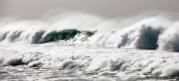istock people walking out onto the ocean while waves crash on rocks 1497422345