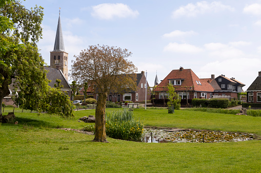 Village view with the church tower of the St martin church in the village of Hallum in Friesland.