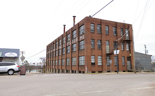 A large factory building on a hilly street on a cloudy day in St. Claire, Missouri