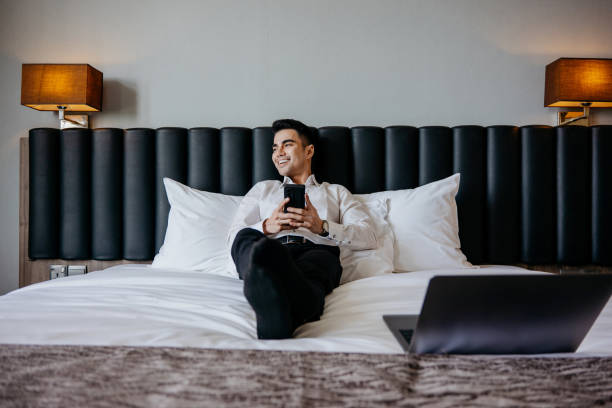 istock Businessman using smartphone in hotel room 1497427694