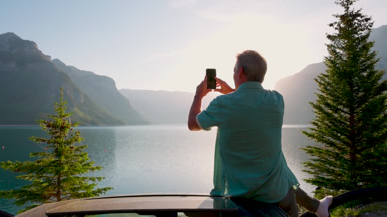 Senior man enjoys view from vehicle roof