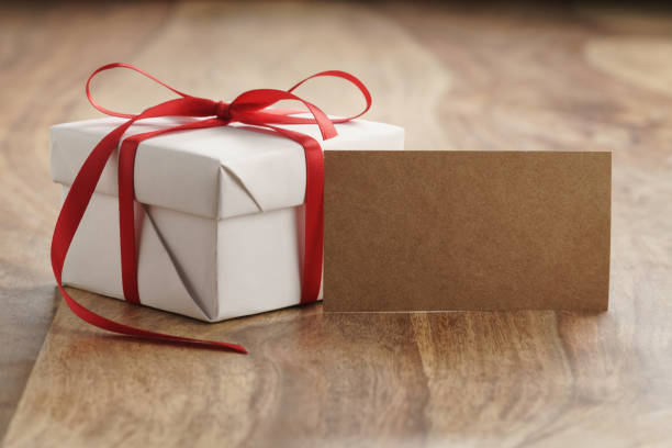 istock white paper gift box with thin red ribbon and paper card on old wood table 1497429143