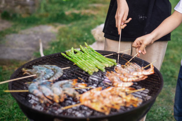istock Round grill with king prawns and asparagus cooked on it. 1497432726