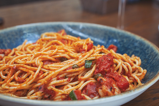 Spaghetti alla puttanesca - italian pasta dish with tomatoes