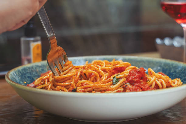 Spaghetti alla puttanesca - italian pasta dish with tomatoes stock photo