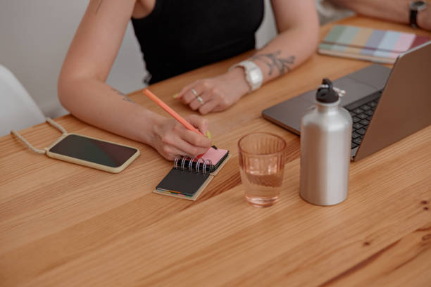 istock Close up of woman freelancer making notes during work in cozy coworking 1497433049
