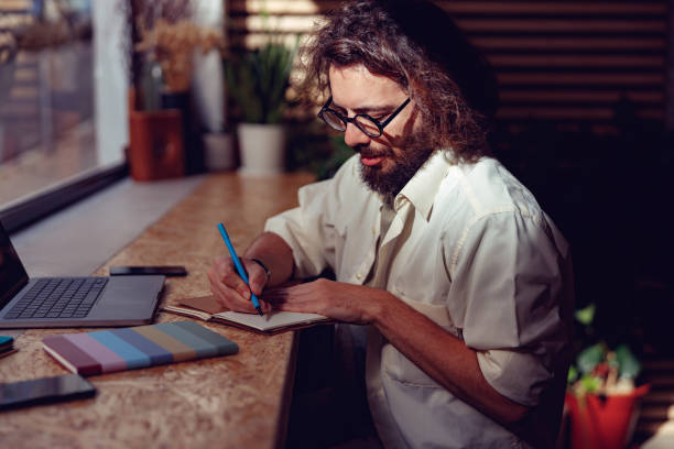 istock Young businessman making notes during working day at coworking space near window 1497433258