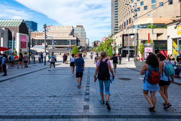 Montreal, Canada - August 28, 2022: people walking along a shopping street with a lot of stores and shops in Montreal