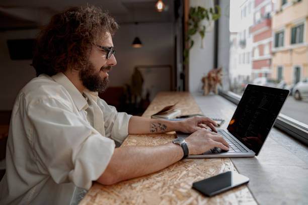 istock Smiling male freelancer working on laptop while sitting in modern coworking. Remote work concept 1497434682
