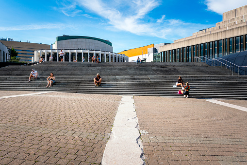 Montreal, Canada - August 28, 2022: some people relax on steps in the pedestrian zone.