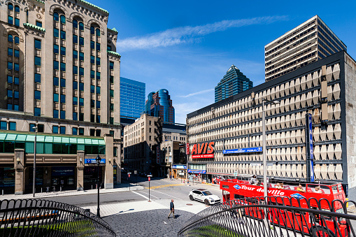 Montreal, Canada - August 28, 2022: A red tourbus between some modern buildings in Montreal