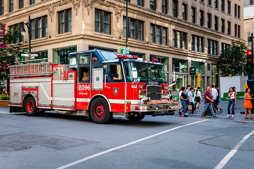 Montreal, Canada - August 28, 2022: A red firetruck between some modern buildings in Montreal
