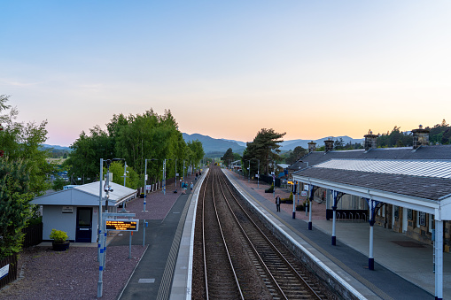 Kingussie Scotland - May 30 2023: The Kingussie Scotland Train Station with People Waiting on the Platform at Sunset