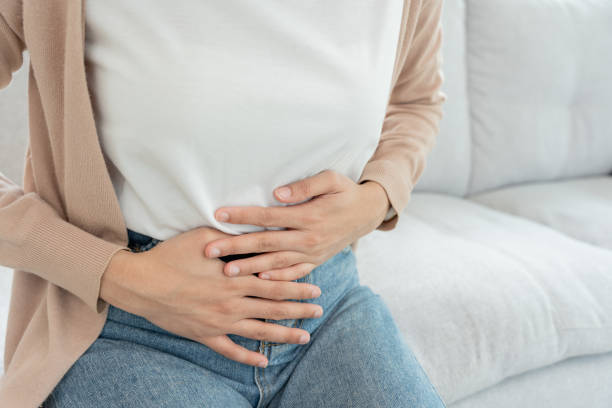 バスルームでの便秘と下痢。痛い女性は腹に触れると痛い。大腸の炎症の問題、有毒な食べ物、腹痛、腹部、トイレで便秘、腹痛、衛生 - 月経前症候群 ストックフォトと画像