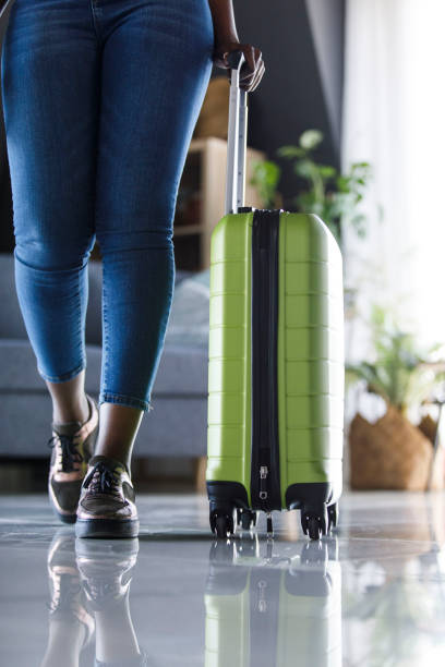 istock Front view of young woman walking towards the camera, dragging her suitcase 1497439058