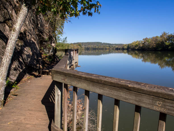 Walkpath by the blank water of Tennesse River and clear blue sky in Ijams Nature Center, Knoxville, Tennessee, USA. stock photo