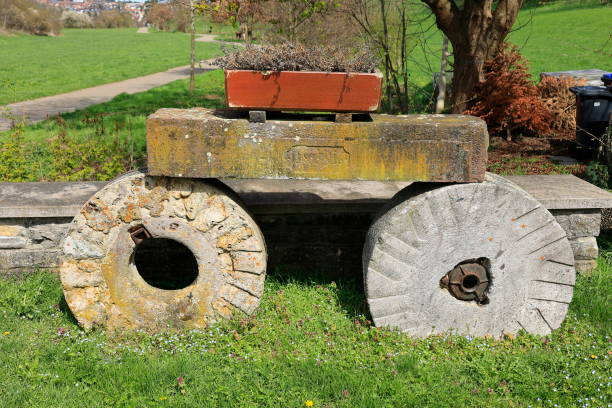 istock Flower pot stands on two old wheels made of stone 1497445402