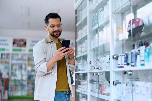 istock Young man using app on cell phone while looking for a medicine in drugstore. 1497445525