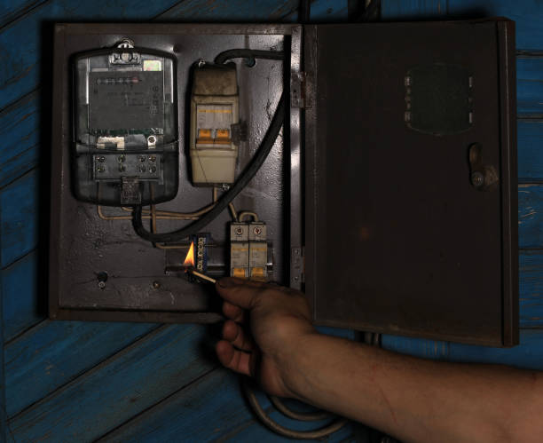 istock Power outage, electric meter, hand in at night holds a burning match 1497446754