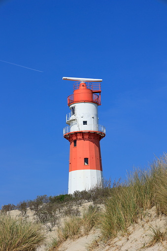 Der elektrische Leuchtturm auf der Insel Borkum steht hinter einer Düne