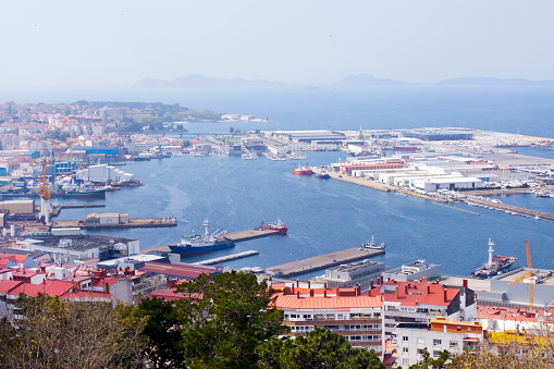 Vigo harbor high angle view, Pontevedra province, Galicia, Spain. Apartment buildings rooftop. Townscape and Cies islands in the fog in the background.
