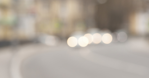 Bokeh blur shot of town street with traffic in spring day, wide photo