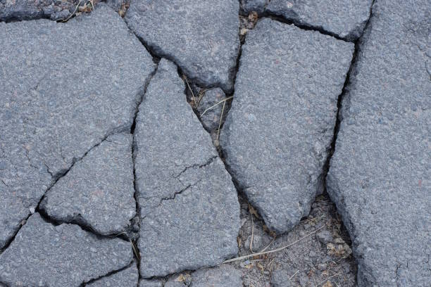 istock gray texture of asphalt on the road with cracks 1497452928