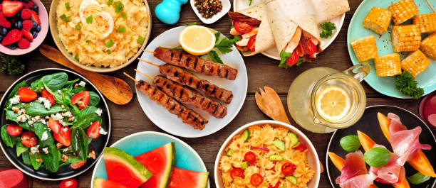 istock Summer food table scene over a dark wood banner background, top down view 1497454072