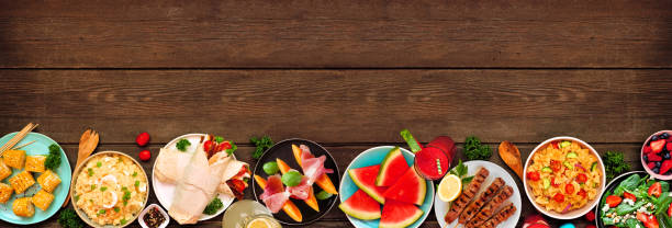 istock Summer food bottom border over a dark wood banner background 1497454085