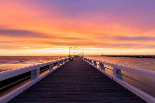 istock Scenic view of a dock illuminated by a setting sun, with a bridge in the background 1497458383