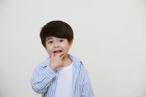 istock A little boy wearing a polite shirt is thinking using his hands to express emotions against a white background. 1497459247