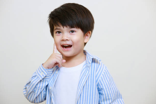 istock A little boy in a polite shirt showing a thoughtful pose using his hands against a white background 1497459371