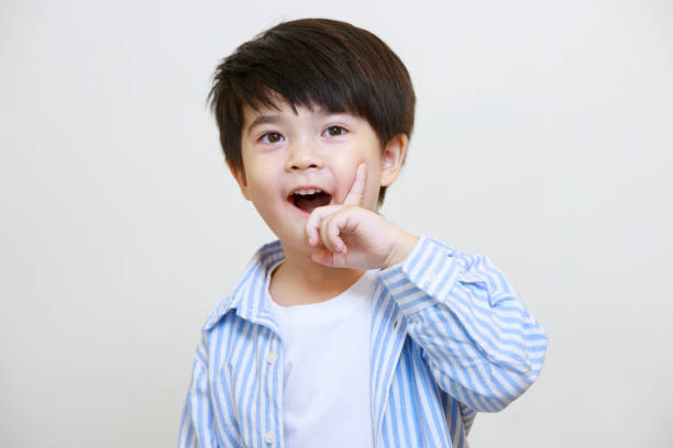 istock A little boy in a polite shirt showing a thoughtful pose using his hands against a white background 1497459373