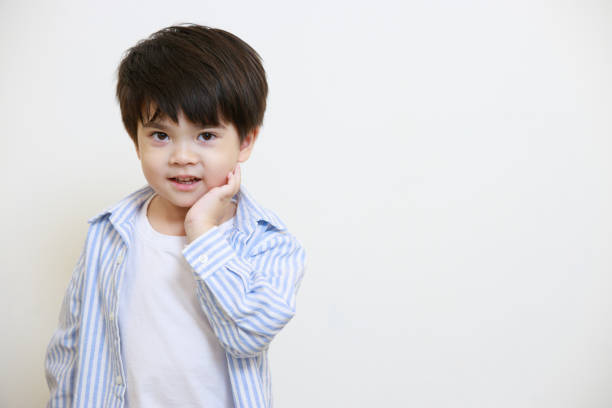 istock A little boy in a polite shirt showing a thoughtful pose using his hands against a white background 1497459406
