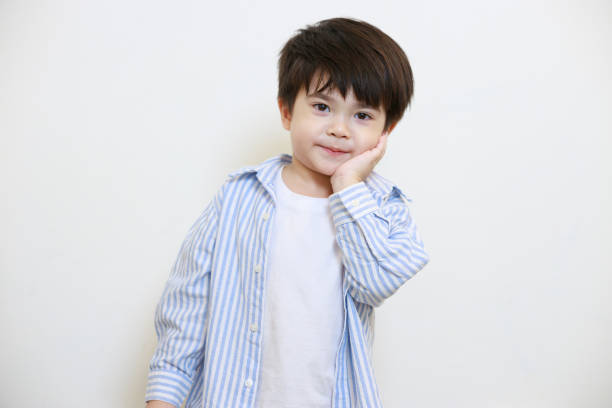 istock A little boy in a polite shirt showing a thoughtful pose using his hands against a white background 1497459408