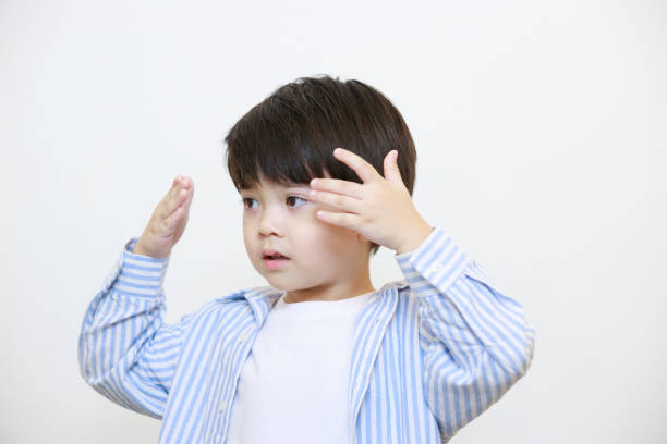 istock A little boy wearing a polite shirt is posing blindfolded on a white background. 1497459456