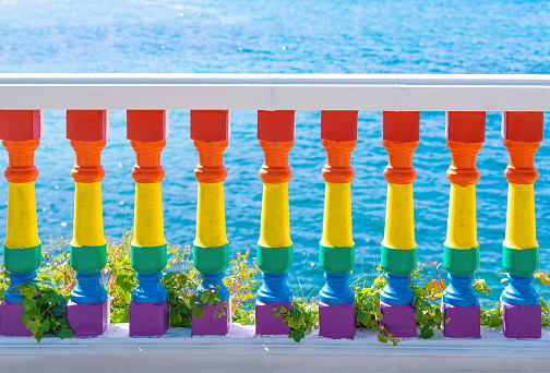 LGTB LGTBIQ+ color painted balustrade rainbow pride with blue sea in background