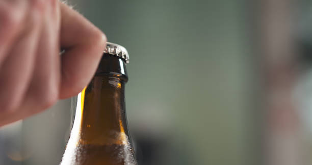 istock man hand opening brown beer bottle closeup 1497469008