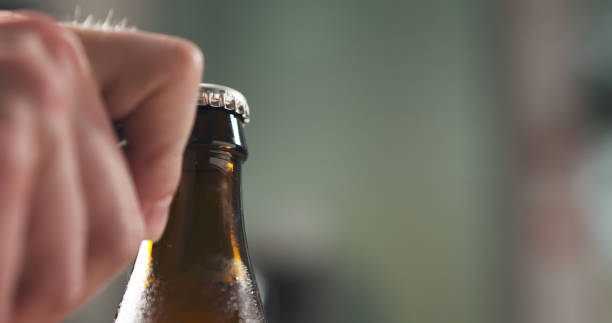 istock man hand opening brown beer bottle closeup 1497469024