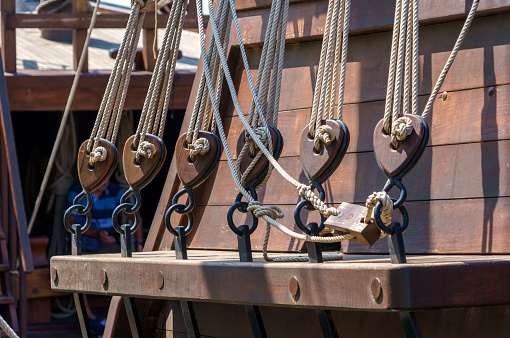 row of ancient ships wooden rigging blocks and reefing lines